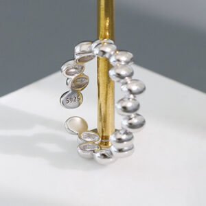 a silver beaded ring on a gold pole
