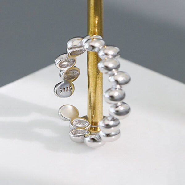 a silver beaded ring on a gold pole