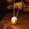 Gold Plated Silver Oval Pendant Necklace on table