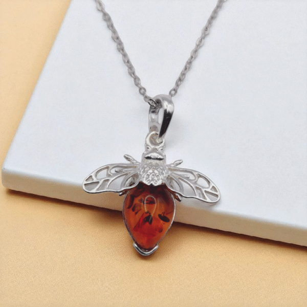 Silver Bee Amber Pendant Necklace on table